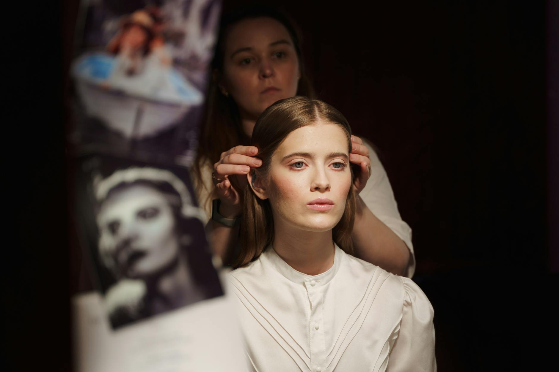 An elegant portrait of a woman getting ready backstage, styled by a professional.