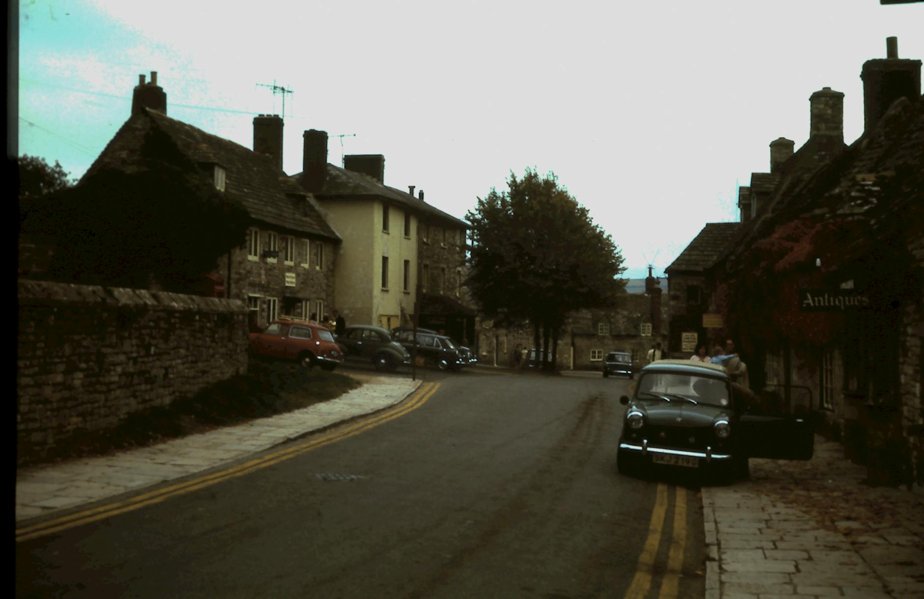 A quaint street in a historic town featuring vintage buildings and a classic car, evoking nostalgia.