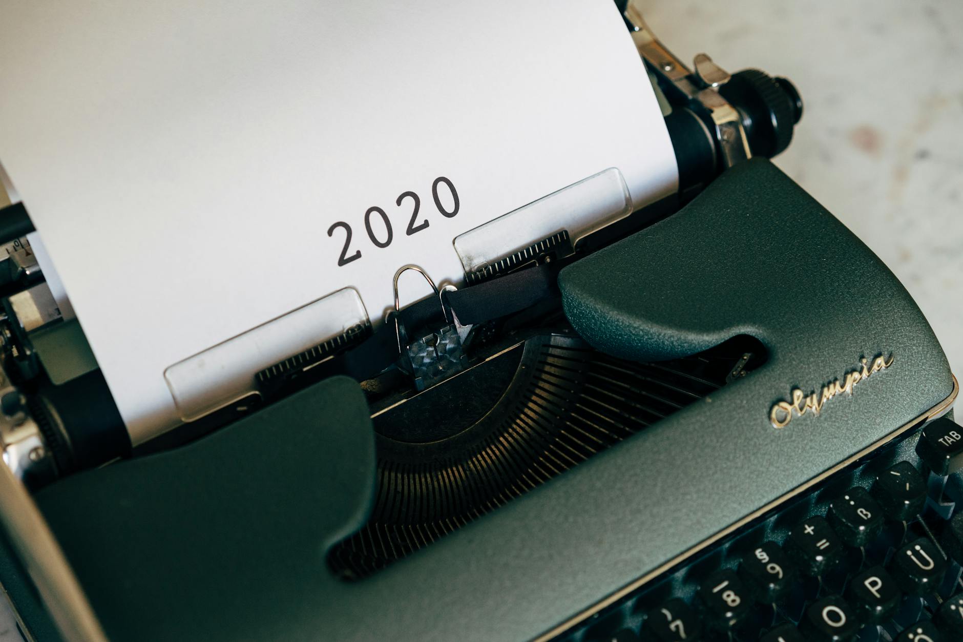 Close-up of a vintage typewriter with the year 2020 on paper, symbolizing past communication.